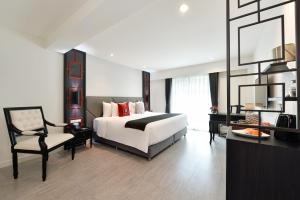 a large bedroom with a bed and a chair at Villa De Pranakorn in Bangkok