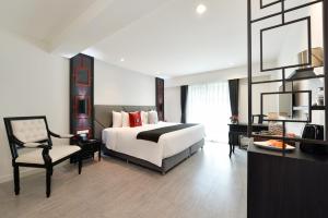 a large bedroom with a bed and a chair at Villa De Pranakorn in Bangkok