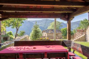 a table on a porch with a view of a house at Дренковите Къщи Drenkovi Houses in Kovačevica