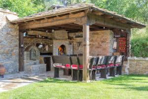 a wooden pavilion with benches and an outdoor oven at Дренковите Къщи Drenkovi Houses in Kovačevica