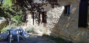 a table and chairs sitting outside of a building at Le fournil de la Blogeonie in Saint-Geniès