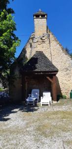 two white chairs sitting in front of a building at Le fournil de la Blogeonie in Saint-Geniès