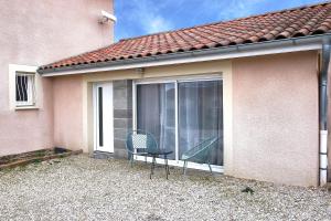 a pair of chairs sitting outside of a house at Au coeur des 3 bâgé in Bâgé-la-Ville