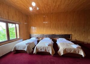 two beds in a room with wooden walls at Lahza Hills Resort in Çaykara