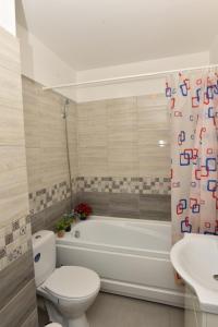 a bathroom with a tub and a toilet and a sink at Mall LuxuryApartment Six in Bacău