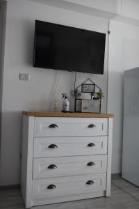 a dresser with a flat screen tv on top of it at Mall LuxuryApartment Six in Bacău