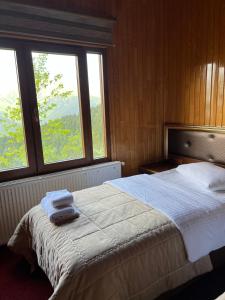 a bedroom with a large bed with two towels on it at Lahza Hills Resort in Çaykara