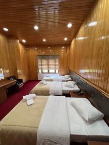 a row of beds in a room with wooden walls at Lahza Hills Resort in Çaykara