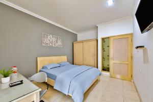 a bedroom with a bed and a desk and a window at Cinere Inn & Residence in Cinere