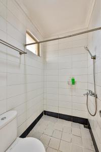 a white bathroom with a shower and a toilet at Cinere Inn & Residence in Cinere