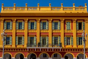 a large yellow building with a balcony at Aparthotel AMMI Nice Lafayette in Nice