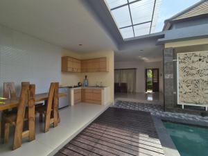 a kitchen with a dining table and a swimming pool at The Bagus in Kerobokan