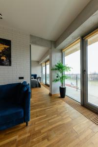 sala de estar con sofá azul y ventanas grandes en Luxury Apartments VENECIA en Úzhgorod