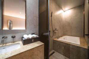 Uiwang Milos Hotel في Uiwang: حمام مع حوض وحوض استحمام
