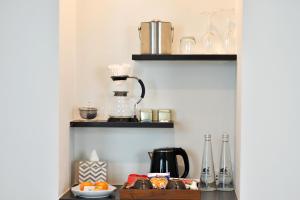 a shelf with a coffee maker and other items on it at Villa De Pranakorn in Bangkok