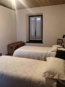 sypialnia z 2 łóżkami i oknem w obiekcie Apartment Madonna Del Sasso/Piemont 22865 w mieście Madonna del Sasso