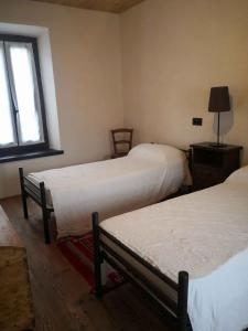Pokój z 2 łóżkami i oknem w obiekcie Apartment Madonna Del Sasso/Piemont 22865 w mieście Madonna del Sasso