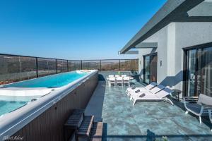 a house with a swimming pool on a balcony at סוויטות בוטיק נעמי in Netu'a