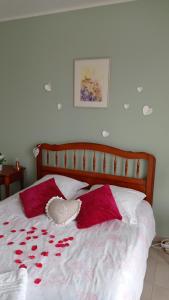Una cama con pétalos de rosa roja. en Les Cigales, en Villelaure