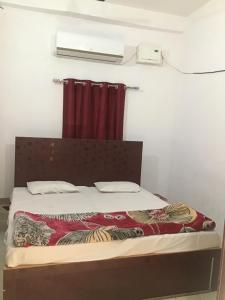 een bed in een kamer met een rood gordijn bij Rita Shree Homestay At Ayodhya Highway in Sultānpur