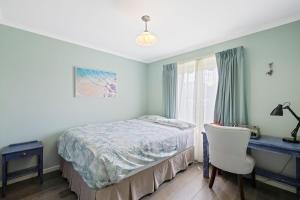sypialnia z łóżkiem, biurkiem i oknem w obiekcie Oceanview Family Retreat w mieście San Remo