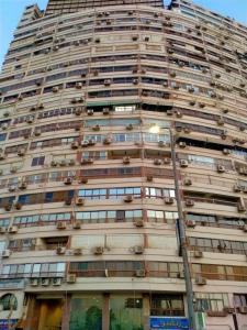 ein großes Gebäude mit vielen Fenstern und einem Straßenlicht in der Unterkunft Big apartment new furnished in Cairo downtown beside Nile river in Kairo
