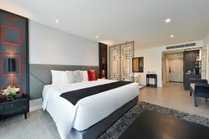 a bedroom with a large white bed and a living room at Villa De Pranakorn in Bangkok