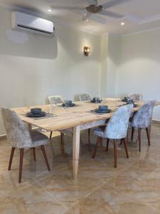 drewniany stół i krzesła w pokoju w obiekcie 3BR Sea View Condo w mieście Dar es Salaam