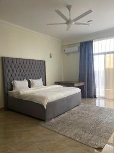 a bedroom with a bed and a ceiling fan at 3BR Sea View Condo in Dar es Salaam