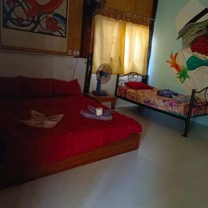 - une chambre dotée d'un lit rouge avec une bougie dans l'établissement Sunny garden hostel, à Pai