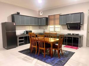 eine Küche mit einem Tisch und Stühlen sowie einem Kühlschrank in der Unterkunft Rumah Tok Wan Dee (Suite 1 Room) 2024 in Wakaf Baharu