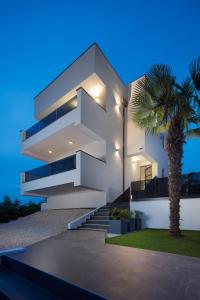 una casa blanca con escaleras y una palmera en Modern villa Dea with jacuzzi and pool in Porec, en Flengi