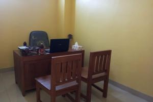 escritorio con 2 sillas y ordenador portátil en Wisma Pelita Syariah en Tegal