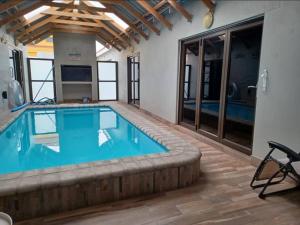 a large swimming pool with blue water in a room at Carlo's Boutique Guesthouse in Walvis Bay