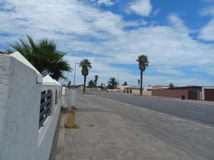 an empty street with palm trees on the side of a road at Carlo's Boutique Guesthouse in Walvis Bay