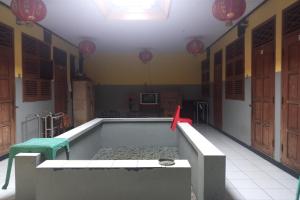 Habitación con bañera, mesa y sillas. en Wisma Pelita Syariah en Tegal
