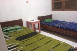 Habitación con 2 camas y mesa. en Wisma Pelita Syariah en Tegal