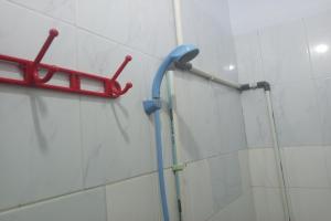 un cabezal de ducha en la pared de un baño en Wisma Pelita Syariah en Tegal