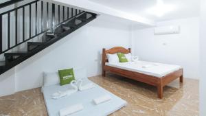 a bedroom with a bed and a stair case at ESerenty Private Villa Pangasinan by RedDoorz in Banaybayan