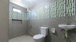 a bathroom with a toilet and a sink at ESerenty Private Villa Pangasinan by RedDoorz in Banaybayan