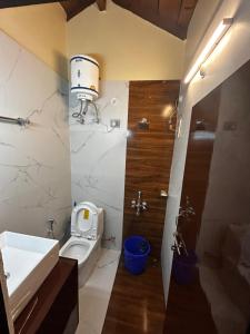 La salle de bains est pourvue de toilettes, d'un lavabo et d'une douche. dans l'établissement Kirola hotels, à Rāmgarh
