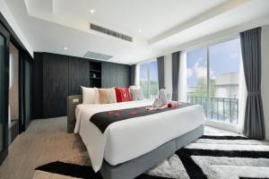 a bedroom with a large bed and a large window at Villa De Pranakorn in Bangkok