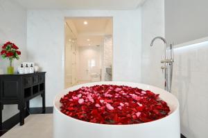 a bath tub filled with red roses in a bathroom at Villa De Pranakorn in Bangkok
