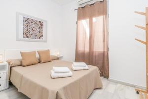 una camera da letto con un letto con due asciugamani sopra di GRX Gran vía Catedral a Granada