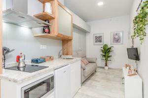 una cucina con mobili bianchi e un soggiorno di GRX Gran vía Catedral a Granada