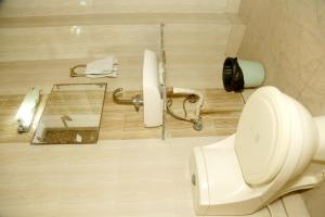 a bathroom with a white toilet and a mirror at Hotel India international Deluxe in New Delhi