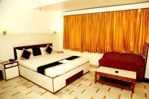 um quarto com uma cama e uma cadeira vermelha em Hotel India international Deluxe em Nova Deli