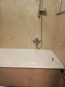 eine Badewanne im Bad mit Dusche in der Unterkunft Parko apartamentai Self check in in Klaipėda