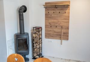 a wood stove sitting next to a wall at Apartmaji Ježek Kope in Šmartno pri Slovenj Gradcu +17 photos