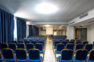 une pièce vide avec des chaises et des rideaux bleus dans l'établissement Blu Hotel - Sure Hotel Collection by Best Western, à Collegno